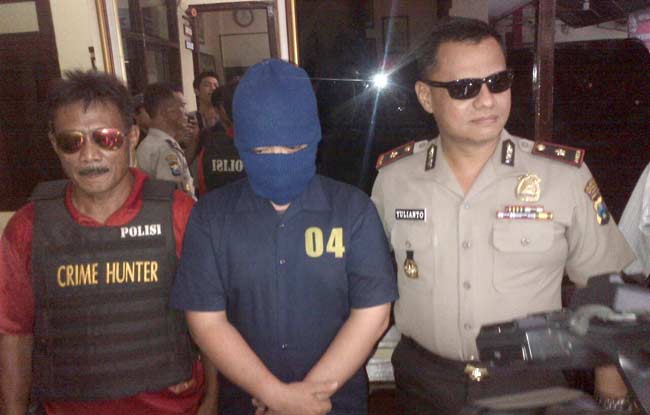 Tersangka diapit Kapolsek dan Kanit Reskrim Sukomanunggal. foto: ekotuyono/ BANGSAONLINE
