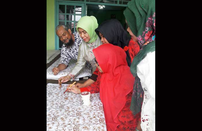 Siti Muafiyah (dua dari kiri) ketika mengajari cara membatik. foto: SYUHUD/ BANGSAONLINE