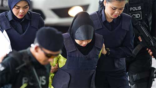 Siti Aisyah dari Indonesia dikawal polisi saat ia tiba di Pengadilan Tinggi Shah Alam di Shah Alam, Malaysia, Rabu (7/11) siang tadi. Siti Aisyah terlibat dalam pembunuhan saudara pemimpin Korea Utara Kim Jong Un. (Foto AP / Yam G-Jun)