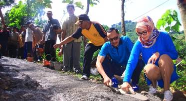 Bupati Probolinggo Hj Tantriana Sari SE melakukan pemlesteran jalan. Foto: andi sirajudin/BANGSAONLINE