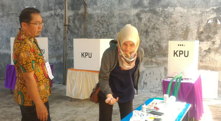 LANCAR: Seorang warga mencelupkan jarinya ke tinta dalam PSU di TPS 09 Desa Kloposepuluh Kecamatan Sukodono, Sabtu (27/4). foto: MUSTAIN/ BANGSAONLINE