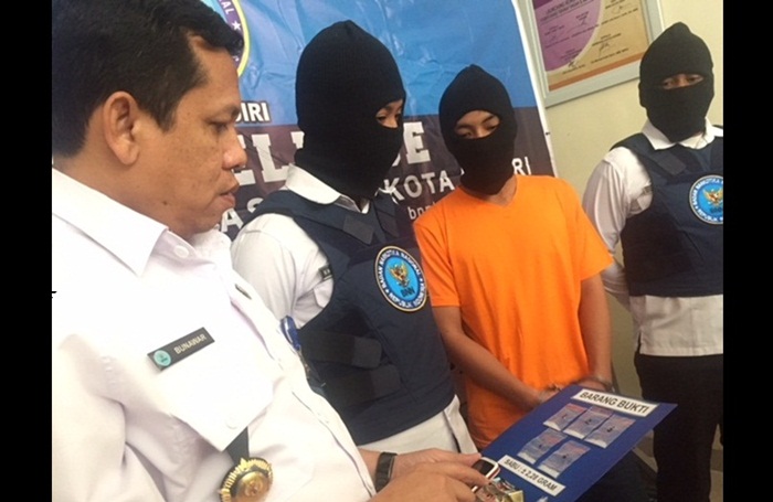 Tersangka berikut barang bukti saat diamankan di kantor BNN Kota Kediri. Foto: ARIF K/BANGSAONLINE

