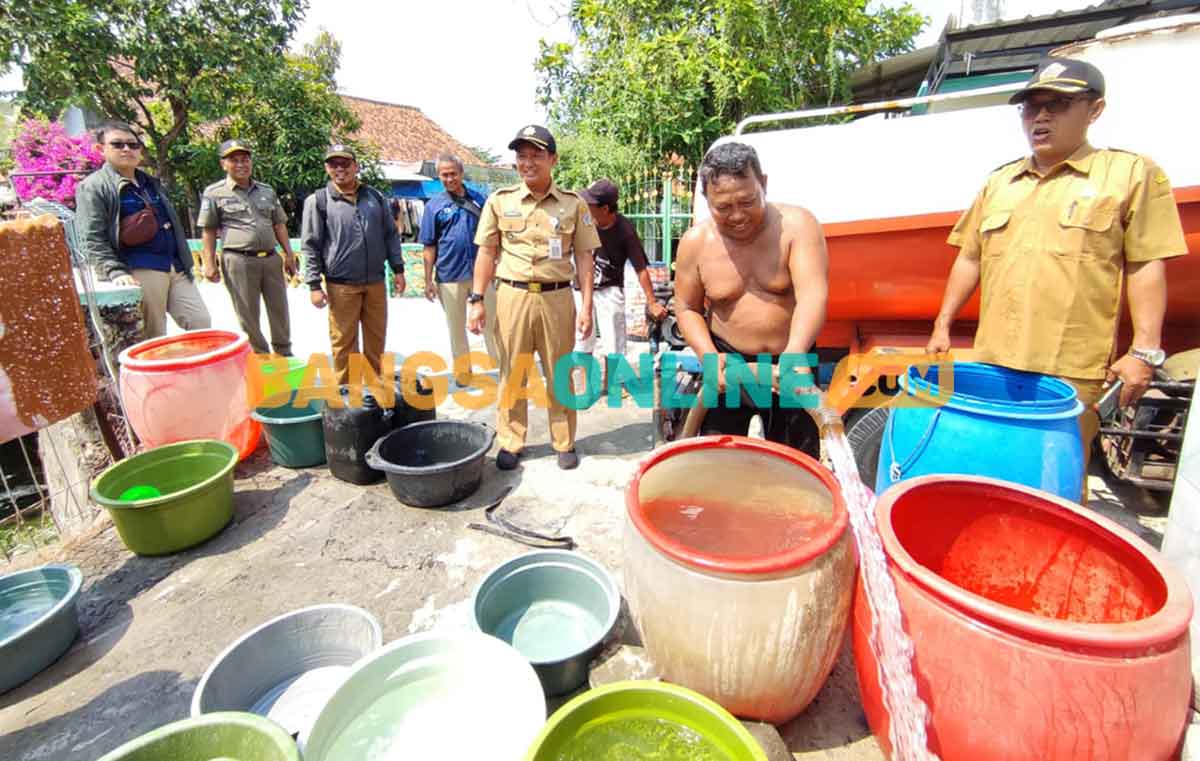 Camat Duduksampeyan, Merista Dedy Hartadi, saat memantau bantuan air bersih di desa-desa yang mengalami krisis air bersih. Foto: SYUHUD/BANGSAONLINE