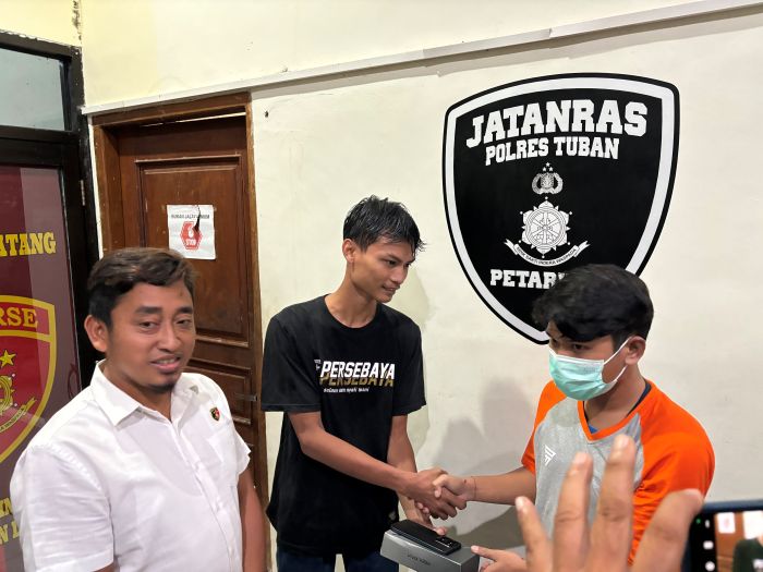 Rohmad (kaos hitam) saat didamaikan dengan pelaku yang menemukan ponsel miliknya di Mapolres Tuban. Foto: Suwandi/BANGSAONLINE