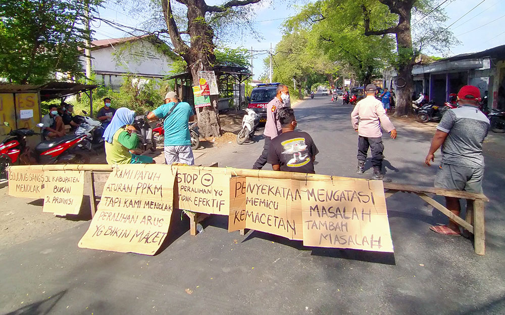 Warga Desa Gununggangsir Kecamatan Beji, Kabupaten Pasuruan saat menggelar aksi demo menutup akses jalan desa setempat, Jum’at (6/10) siang.