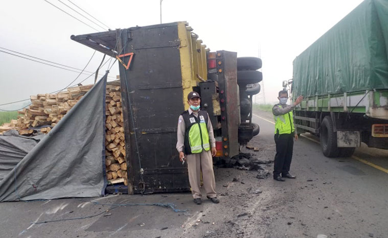 Kondisi truk yang terguling di arteri Porong sebelum dievakuasi petugas.