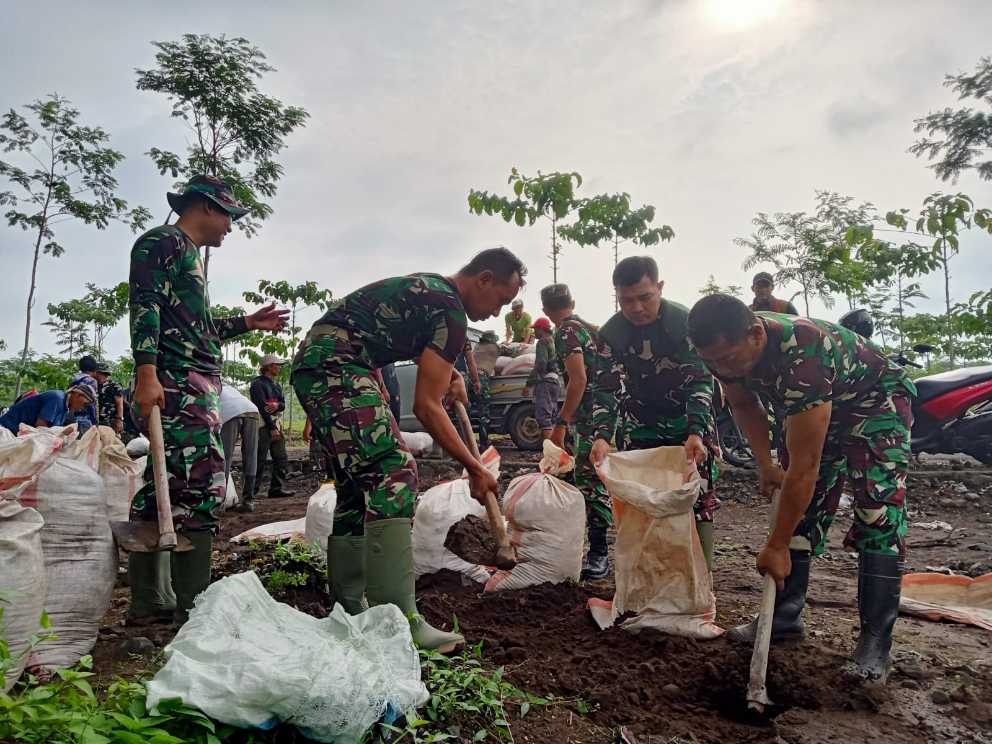 Satgas TMMD dan Warga Gelar  saat kerja bakti membersihkan sisa lumpur