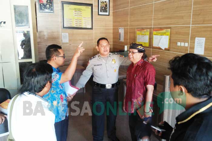 Ketua PWI Jombang, Sutono (baju merah) didampingi kuasa hukum Lilik Yulianto saat melapor ke SPKT Polres Jombang, Jumat (7/7/2017). foto: ROMZA/ BANGSAONLINE