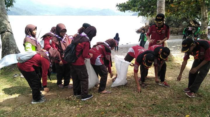 Para Siswa MTsN 1 Trenggalek saat bersih-bersih sampah di Pantai Mutiara. foto: HERMAN/ BANGSAONLINE