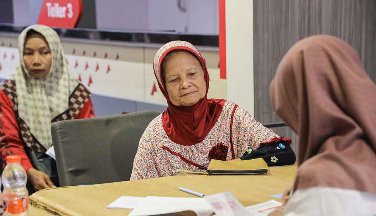 Petugas dari DInsos Kota Kediri saat melayani salah satu masyarakat penerima bantuan. Foto: Ist