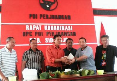 Keenam petinggi parpol koalisi saat potong tumpeng di Kantor DPC PDIP Sidoarjo di  Jalan Raya Jati, kemarin. Foto : mustain/BANGSAONLINE
