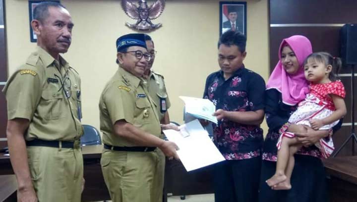 Bupati Rijanto menyerahkan dokumen Adminduk kepada warga yang mengurus Adminduk menggunakan E-SIAP.