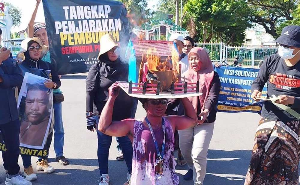 Sejumlah jurnalis di Pamekasan saat menampilkan aksi teatrikal peristiwa dugaan pembunuhan wartawan beserta keluarganya. Foto: DIMAS MS/ BANGSAONLINE