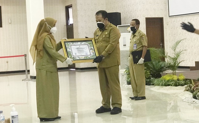 Bupati Hendy menyerahkan penghargaan kepada salah satu sekolah.