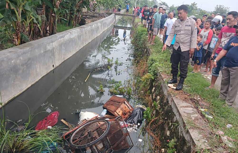 Petugas menunjukkan lokasi penemuan mayat tukang becak di dalam parit.