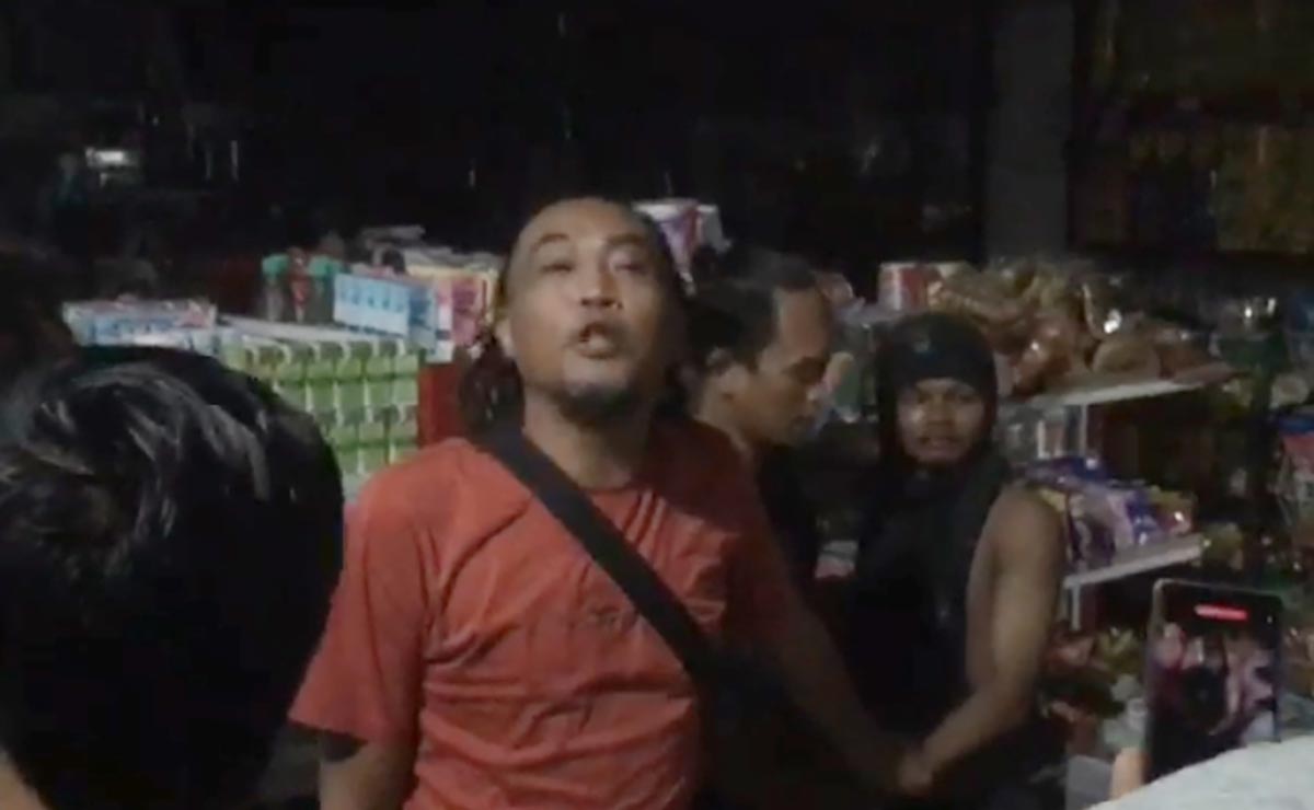 Tersangka A (kanan) saat diamankan petugas dari amukan warga usai turun dari plafon toko milik Mamik. Foto: Ist.