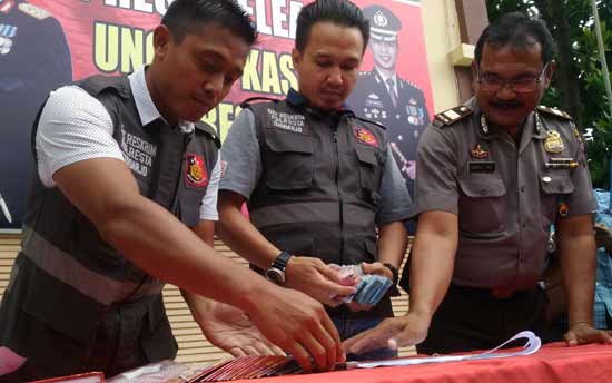 Kasatreskrim Kompol Manang Soebekti (tengah), Kanit Tipidkor Iptu Hari Susanto (kiri) dan Kasubbag Humas AKP Samsul Hadi, saat menata uang hasil OTT. foto: nanang i/ BANGSAONLINE