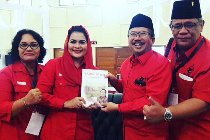 Bambang DH sat menyerahkan sebuah buku berjudul 