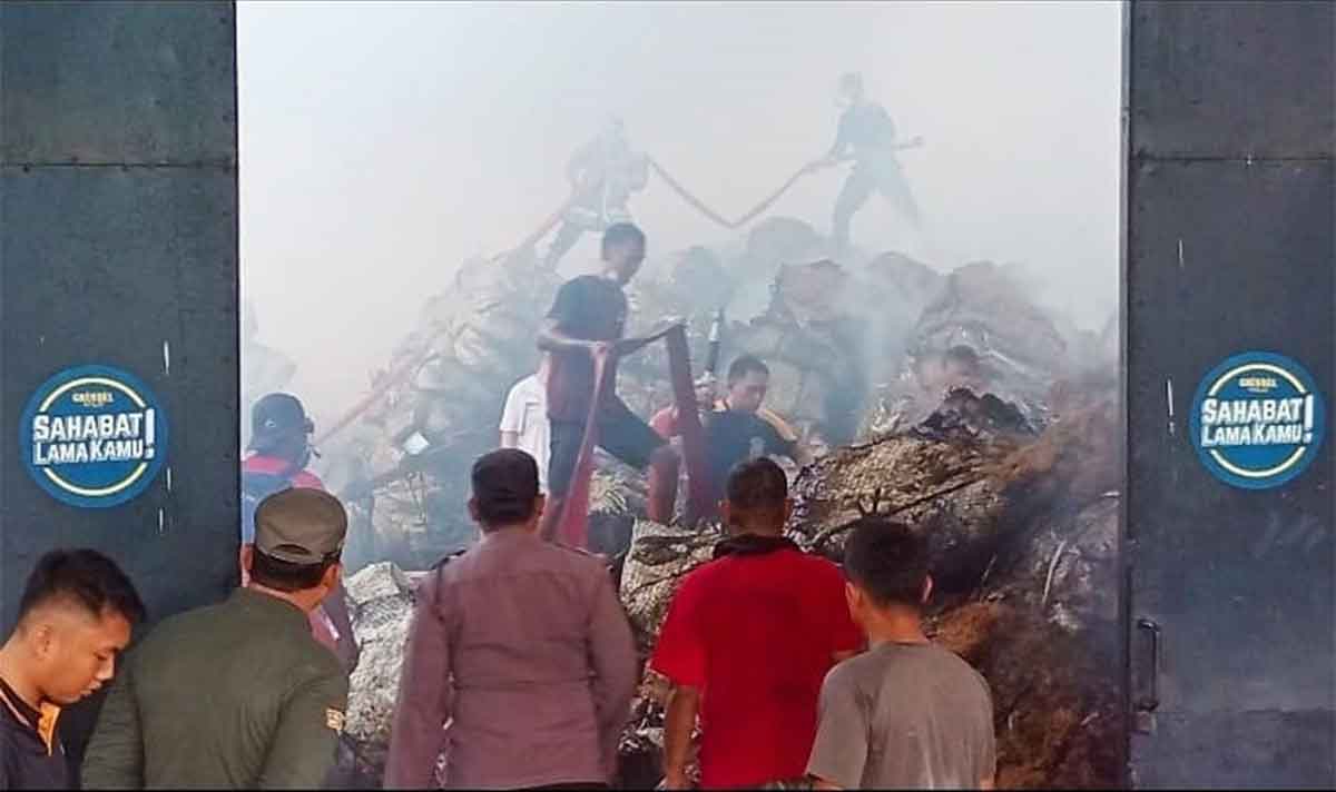 Petugas Damkar Pamekasan saat berupaya memadamkan api di gudang penyimpanan tembakau.