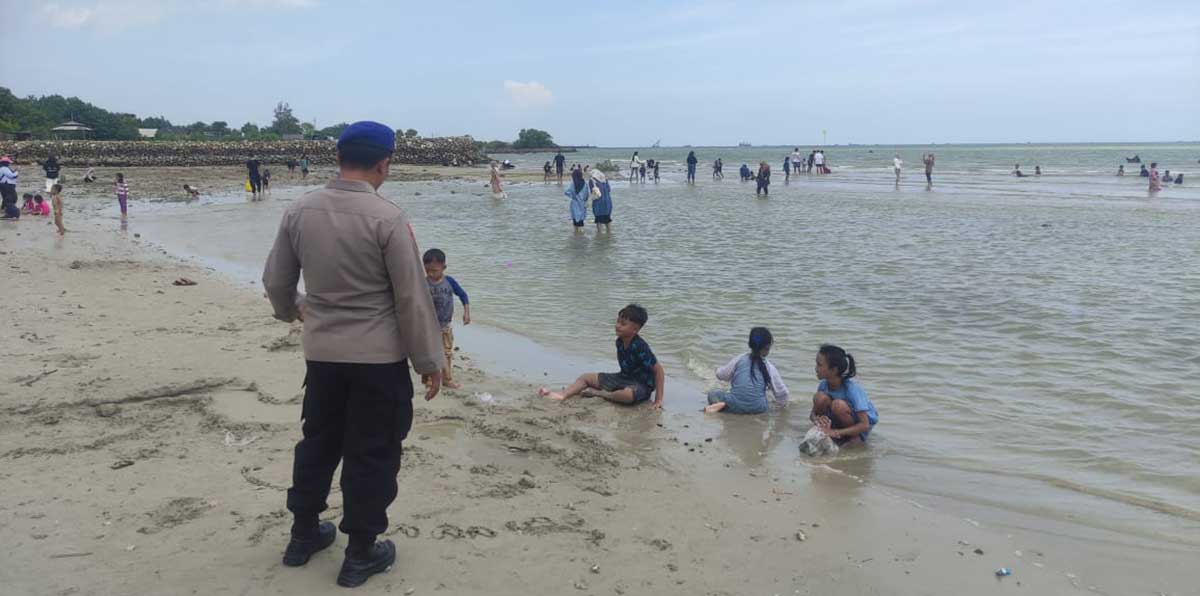 Petugas dari Satpolairud Polres Gresik saat melakukan pengamanan wisatawan di Pantai Dalegan. Foto: Ist