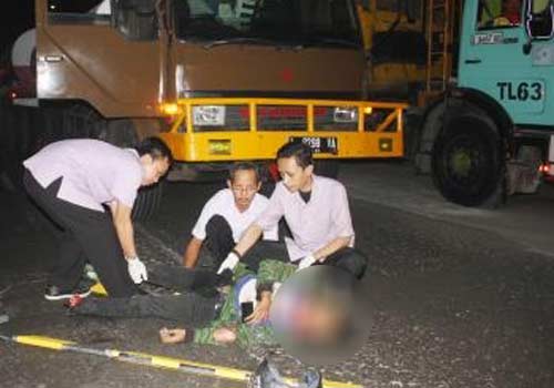 TERKAPAR-Korban sesaat setelah motornya menabrak truk gandeng di Bypass Jampirogo Sooko. (gunadhi/BANGSAONLINE)