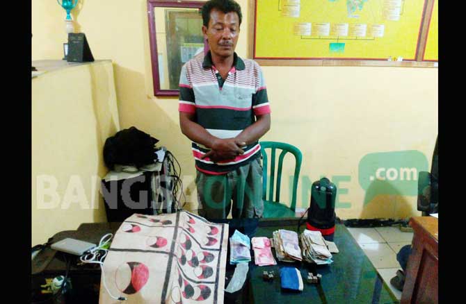 Pelaku bersama beberapa barang bukti berupa beberan, dadu dan uang tunai hasil judi. foto: GUNAWAN WIHANDONO/ BANGSAONLINE