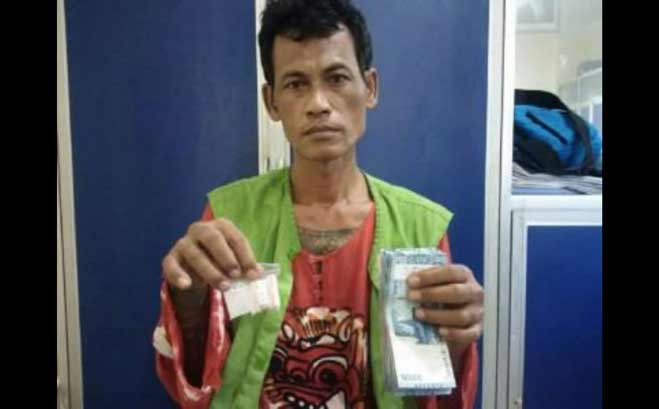 Tersangka Nurhari saat menunjukan sabu siap edar dan sejumlah uang di Mapolrestabes Surabaya.