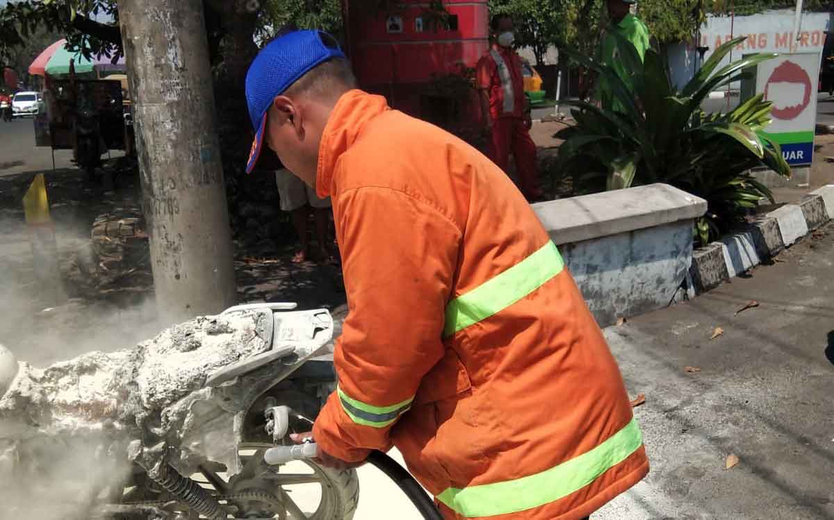 Petugas saat memadamkan motor yang terbakar di Sidoarjo.