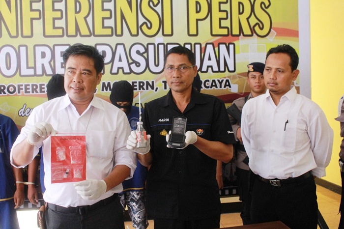 Kasat Narkoba Polres Pasuruan didampingi Kasubag Humas saat menunjukan barang bukti yang berhasil disita dan empat tersangka yang berhasil diamankan. Foto: ANDY F/BANGSAONLINE