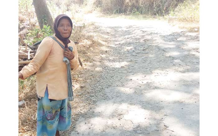 BUTUH PERHATIAN. Tampak seorang warga yang sedang melewati Jalan Sumberbendo-Tulung seperti melewati jalan makadam.
