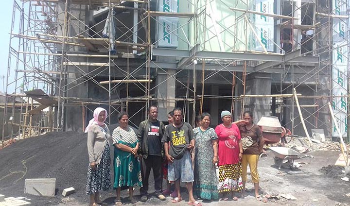 Beberapa warga tampak foto di depan proyek pembangunan kantor pelayanan kesehatan.