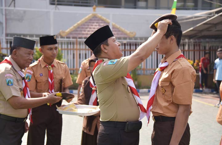 SIMBOLIS: Kalapas melakukan penyematan baret anggota Pramuka pada warga binaan, Jumat (12/10). foto: ist