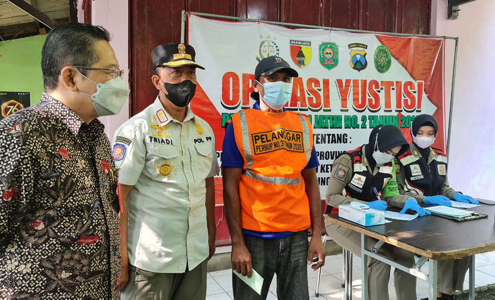 Dari kiri, Pj. Sekda Trenggalek Andriyanto, Kasatpol PP Triadi Atmono, dan pelanggar prokes foto bersama. foto: HERMAN/ BANGSAONLINE