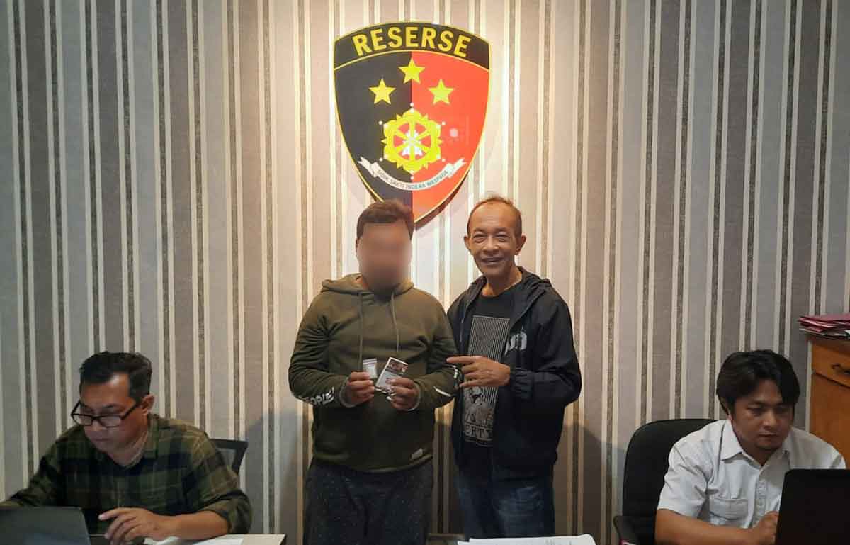 Pelaku saat diapit Kanit Reskrim Polsek Gubeng di ruang penyidikan.
