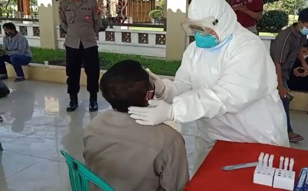 Petugas melakukan rapid test antigen terhadap pengendara yang terjaring operasi yustisi.