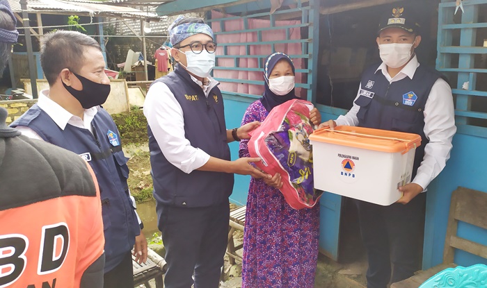 Bupati Pamekasan Baddrut Tamam didampingi Kadis Sosial dan Kepala BPBD Kabupaten Pamekasan saat menyerahkan bantuan kepada korban banjir di Kelurahan Gladak Anyar.