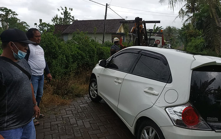 Honda Brio warna putih nopol P-1163-GI yang mencurigakan dan terparkir lama di pinggir jalan dekat area persawahan Dusun Curahpalung, Desa Kradenan, Kecamatan Purwoharjo. (foto: ist)