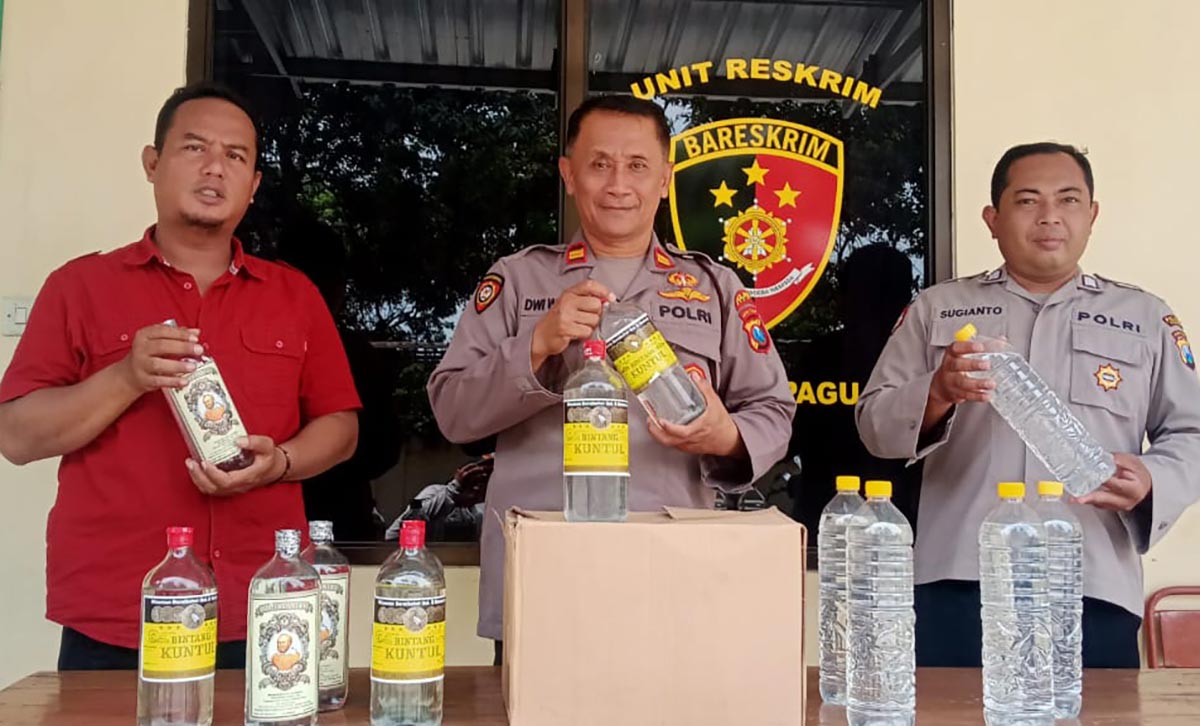 Petugas Unit Reskrim Polsek Pagu saat menunjukkan barang bukti puluhan botol minuman keras. Foto: Ist.