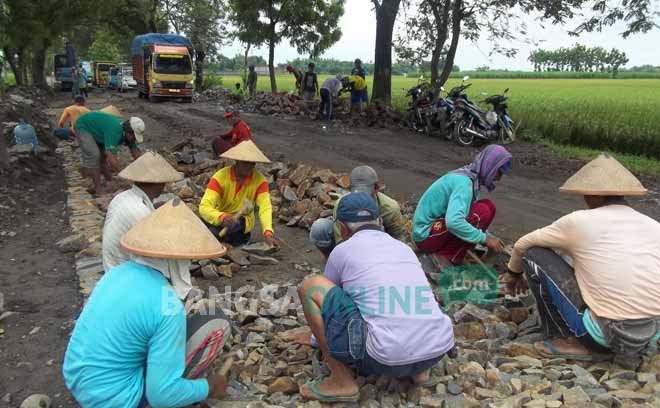 Pengerjaan makadam di Jalan Provinsi yang menghubungkan Kediri ke Nganjuk, Madiun, maupun Bojonegoro, di Desa Tiripan, Kecamatan Berbek, Nganjuk.