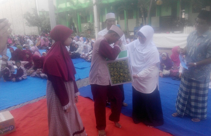BERBAGI: Waka Kesiswaan SMK Antartika 2 simbolis menyerahkan santunan kepada anak yatim piatu, Jumat (8/6). Foto: MUSTAIN/BANGSAONLINE
