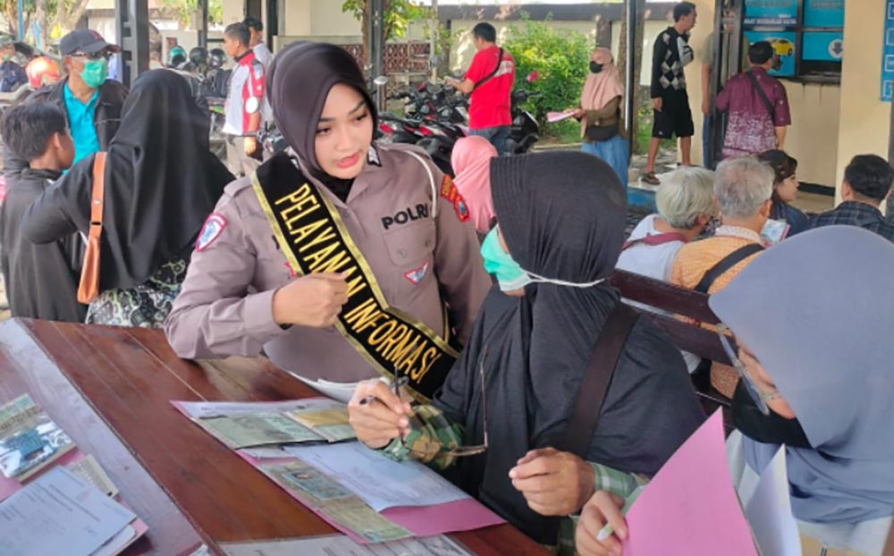 Petugas pendamping yang bertugas di Samsat Sidoarjo saat memberikan arahan kepada warga yang sedang mengurus pajak kendaraan.