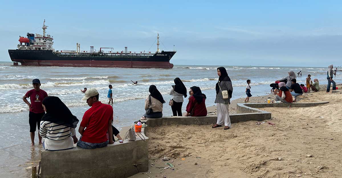 Para wisatawan saat melihat Kapal Tanker MT Abigail W yang kandas di Pantai Panduri, Desa Tasikharjo, Kecamatan Jenu, Tuban.