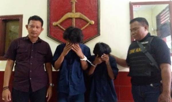 Kedua tersangka saat diamankan di Polsek Tandes Surabaya.