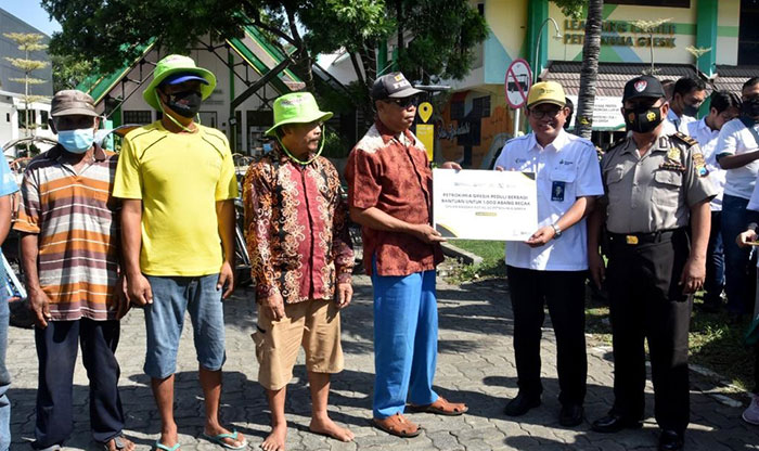 Direktur Utama Petrokimia Gresik, Dwi Satriyo Annurogo (dua dari kanan) saat menyerahkan bantuan kepada tukang becak. Foto: Ist