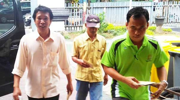 Kedua tersangka (kiri dan belakang) turun dari mobil Kejari, dengan didampingi petugas yang siap menjebloskan ke Tahanan Lapas Kelas II A Sidoarjo. foto: nanang ichwan/ BANGSAONLINE