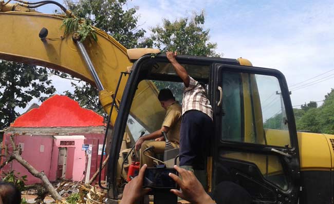 Bupati Ipong saat mengendalikan buldozer untuk membongkar eks lokalisasi Kedung Banteng. foto: BANGSAONLINE