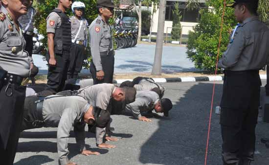 Kapolres Magetan memberikan hukuman push-up kepada anggota yang kedapatan kendaraannya masih tampak kotor saat Sidak dalam apel operasi ketupat 2015. (foto: nanang/BANGSAONLINE)