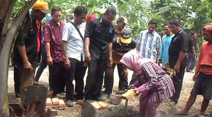 SIMBOLIS – Kabid Pemberdayaan Masyarakat BPMPKB Sidoarjo Sri Rukiyati meletakkan batu pertama pembangunan saluran air program PLPBK, di Desa Keper Kecamatan Krembung, Kamis (25/12/2014). foto istimewa