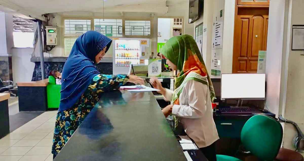 Petugas dari BPJS Kesehatan saat melayani salah satu pasien.