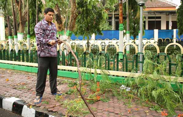 Wali Kota Kediri Abdullah Abu Bakar saat terjun langsung membersihkan pohon yang roboh diterpa hujan dan angin kencang. foto: arif kurniawan/ BANGSAONLINE